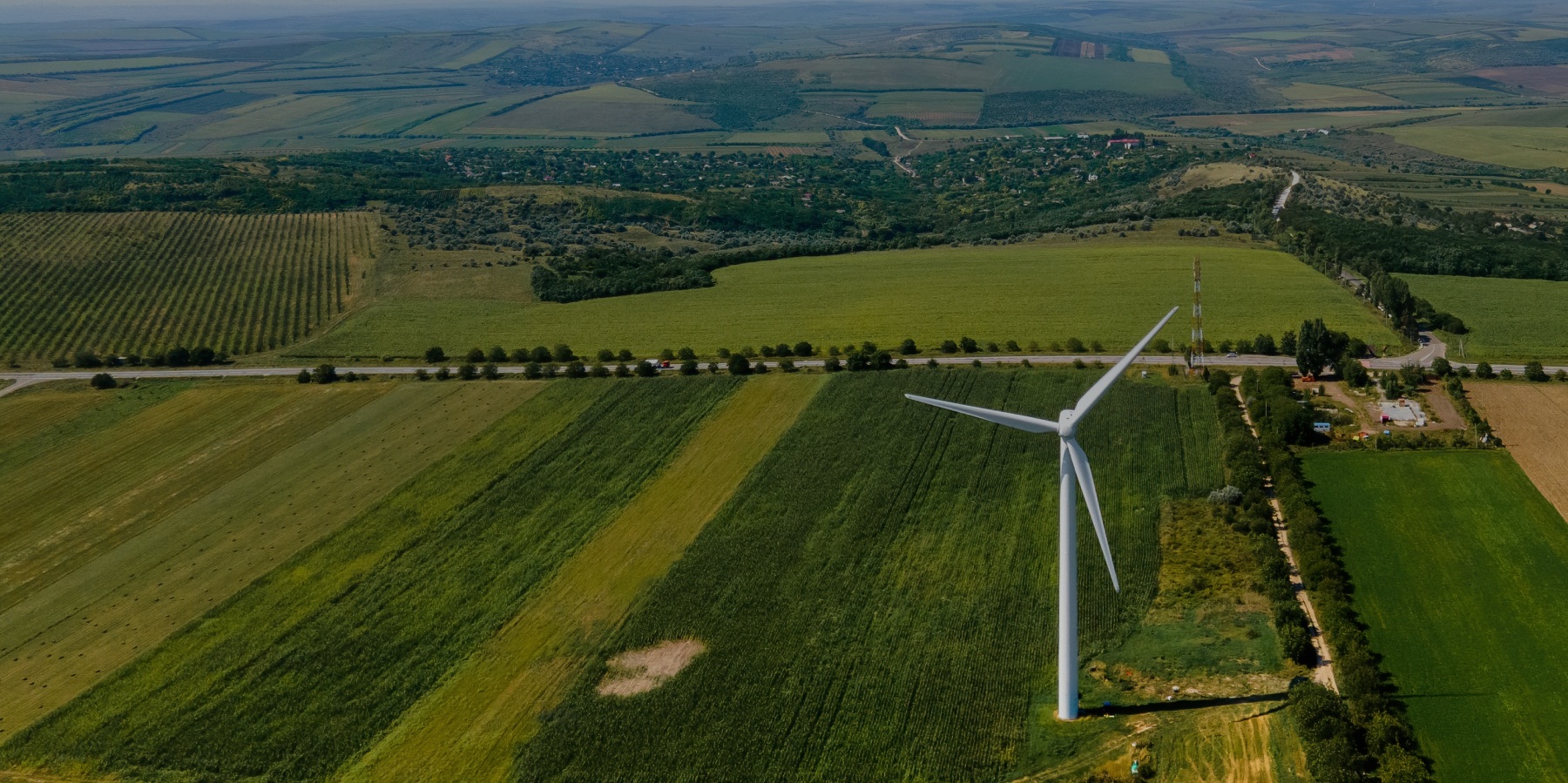 Aerial shot of a wind turbine in a green field